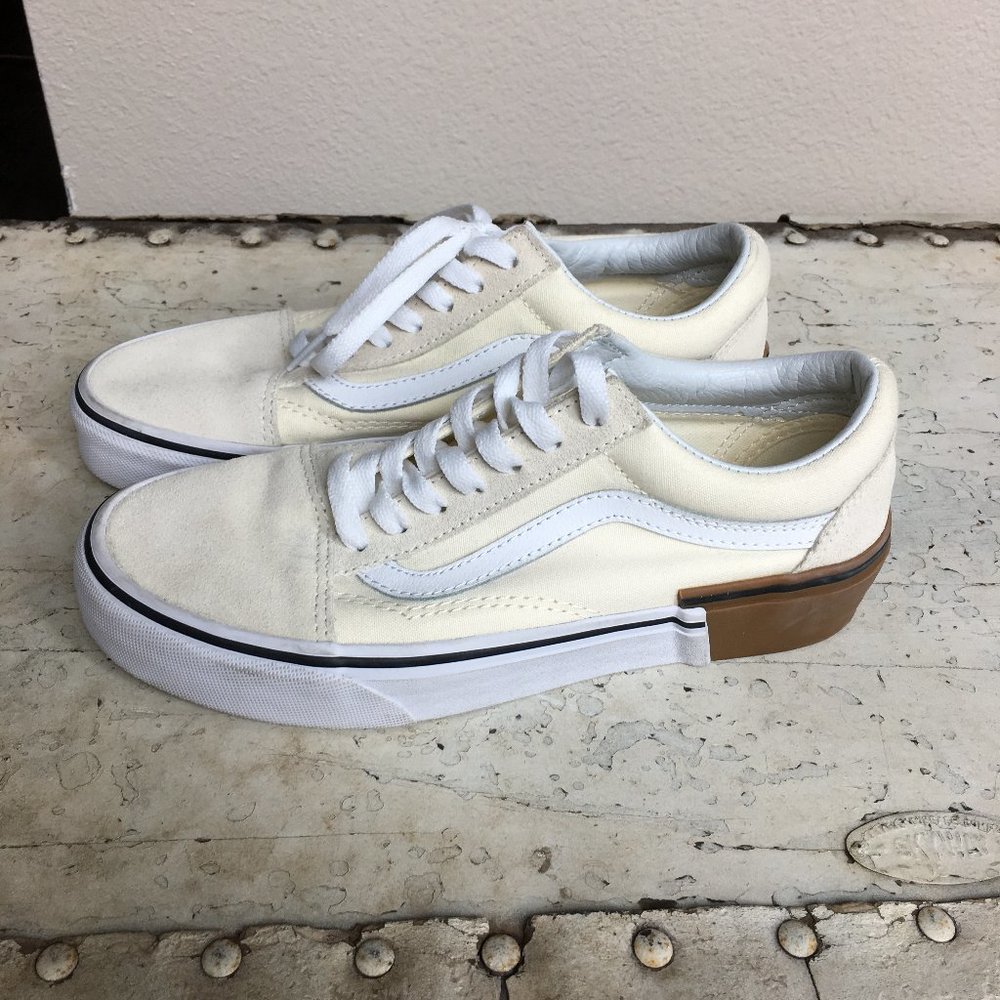 cream colored canvas leather low top Vans sneakers